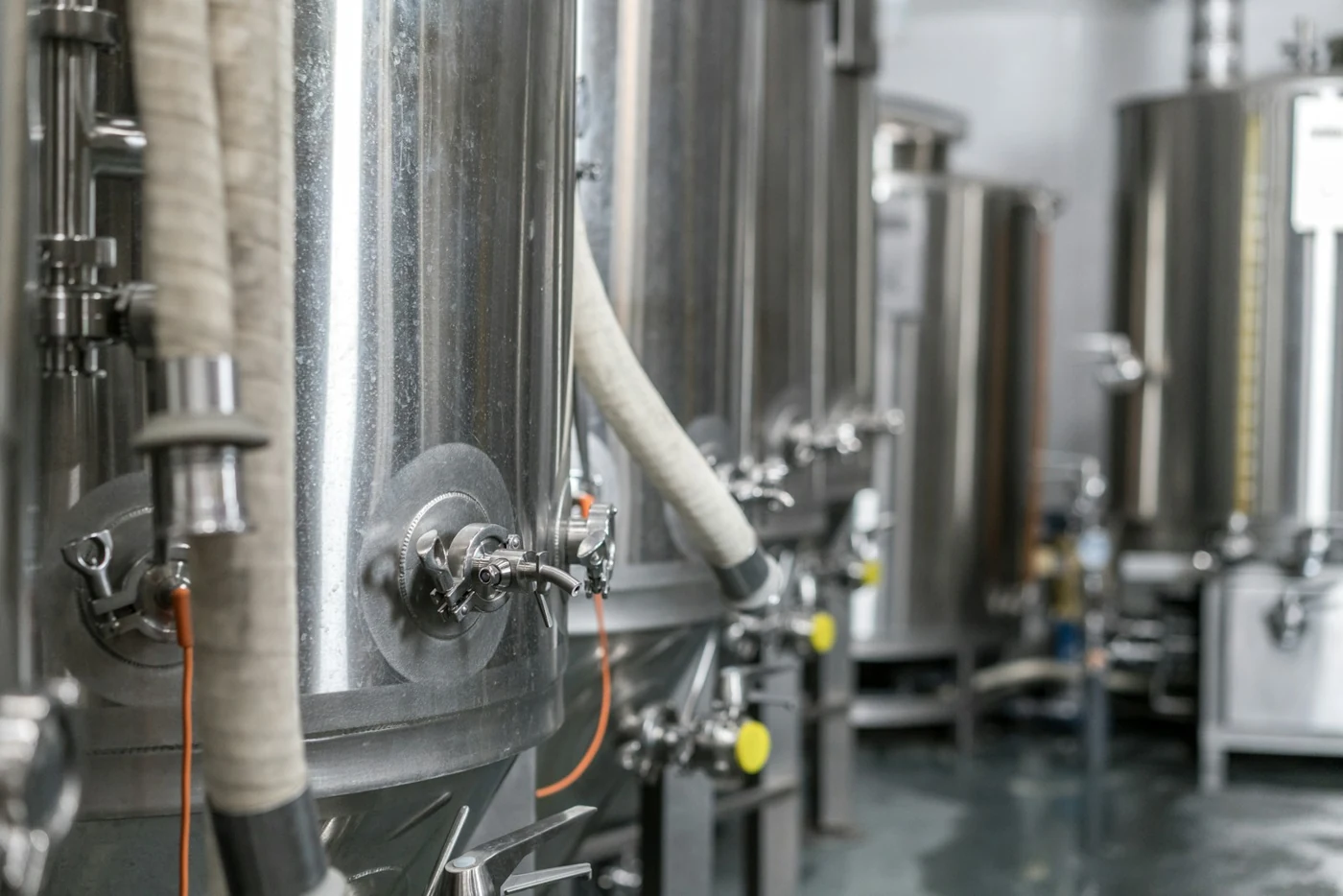 Brewery tanks with connected flexible transfer hoses